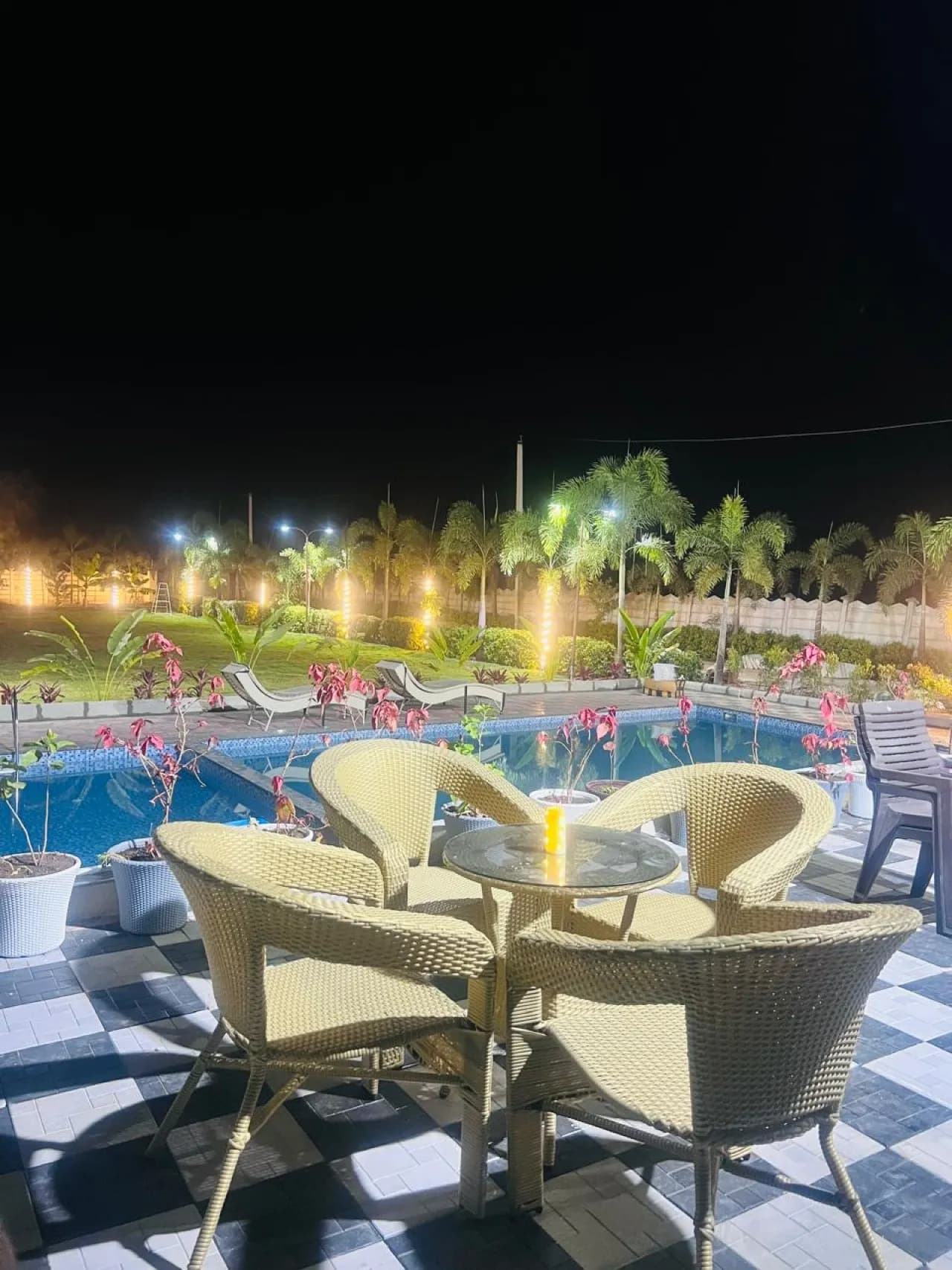 Pool lit up at night at HY FARMSTAY, Moinabad