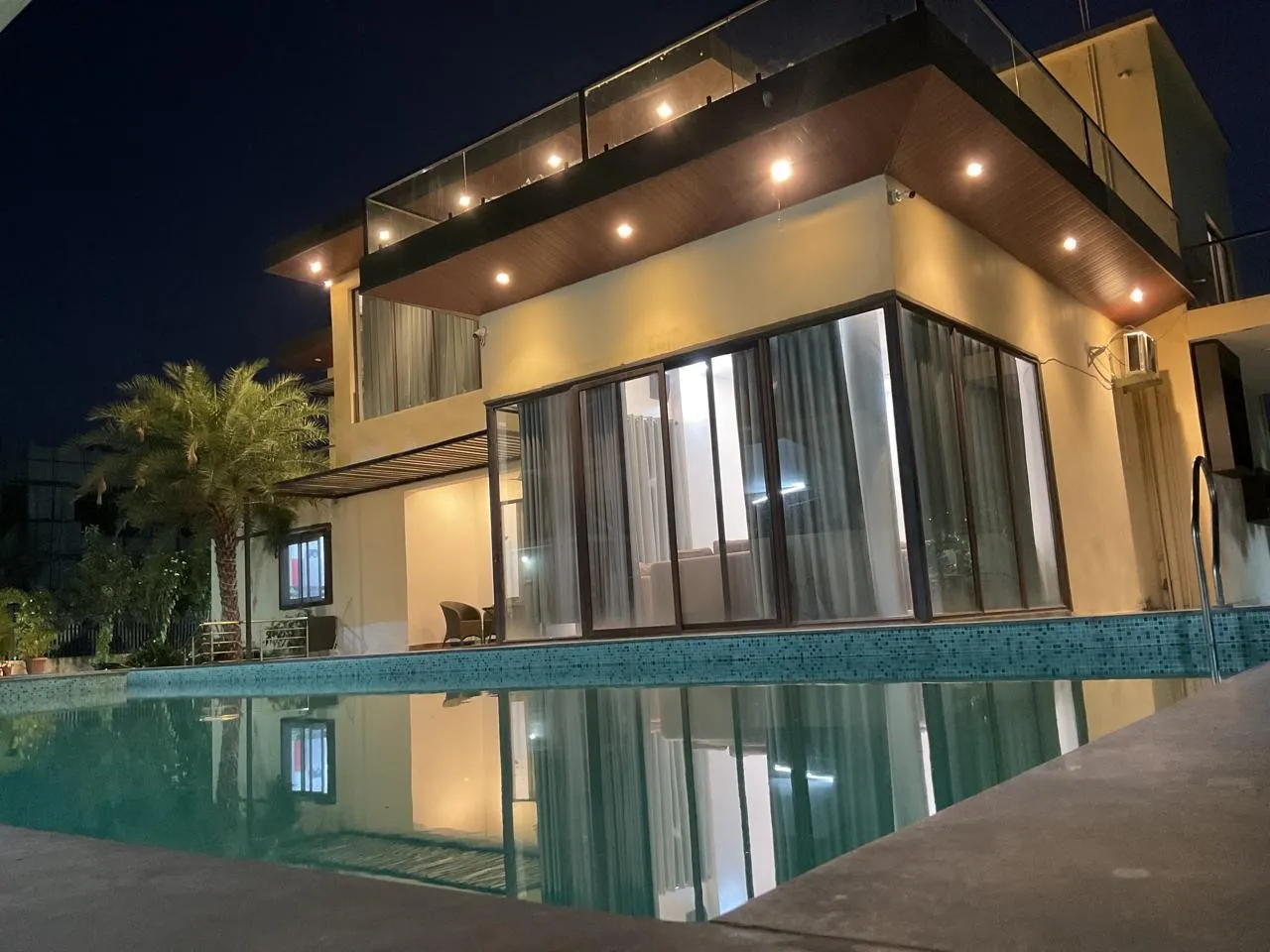 Pool lit up at night at Charan's Villa, Moinabad